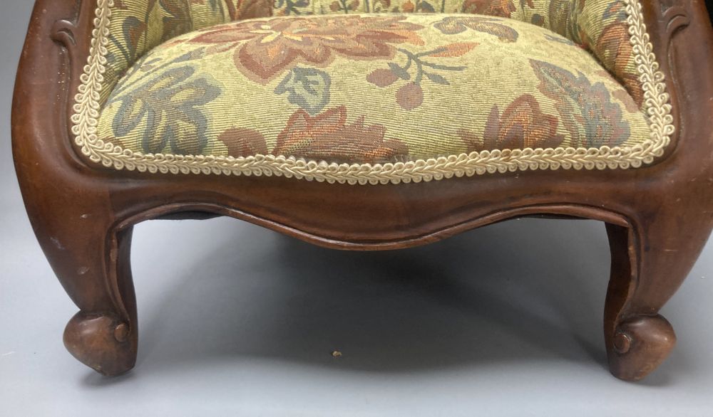 A reproduction miniature spoonback armchair
